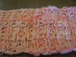 Close up of pink spun yarn knitted into scarf thumbnail.