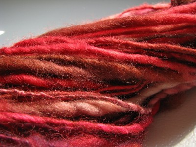Red, brown, and white spun yarn close up.